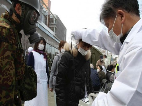 Equipe médica japonesa medindo níveis de radiação da população